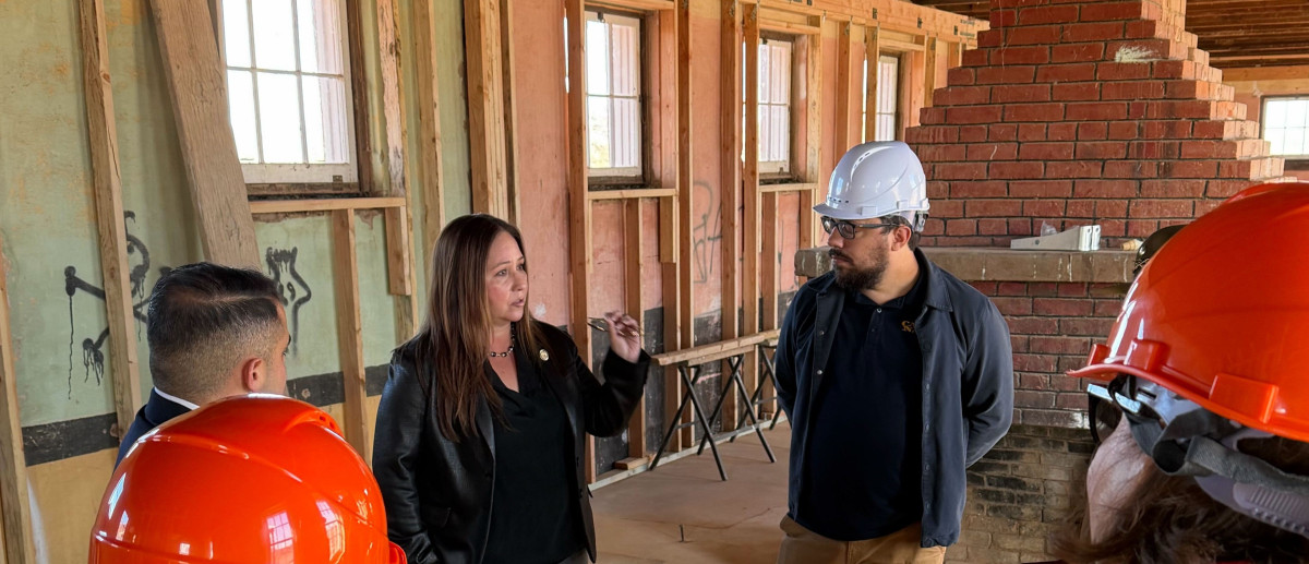 Representative Grijalva speaking with man in hard hat in a construction area.