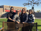 Adelita and her family alongside the bench dedicated to her father