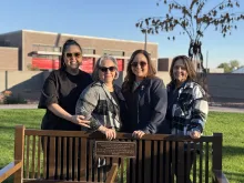 Adelita and her family alongside the bench dedicated to her father